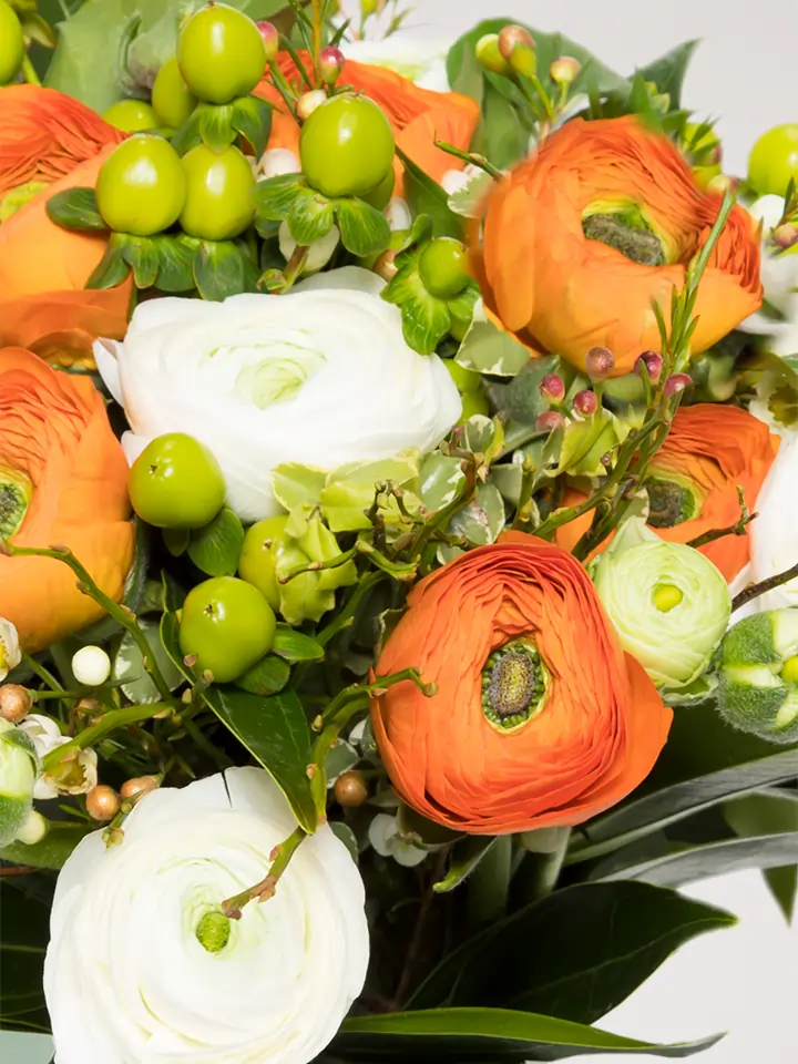 Bouquet ranuncoli arancio e bianchi e bacche verde dettagli